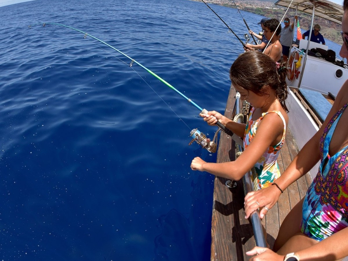 a young girl standing next to a body of water
